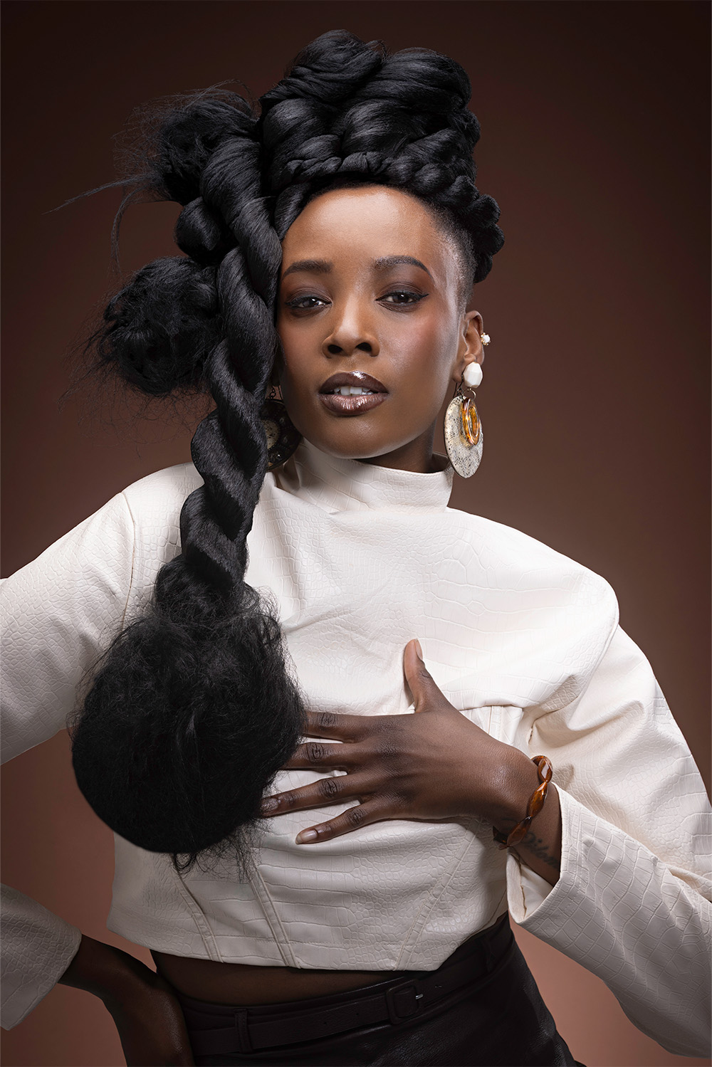 Tamara Robinson- BHA Midlands Hairdresser of the Year 2025 - Dark, intricately braided top knot with a long, thick rope braid 